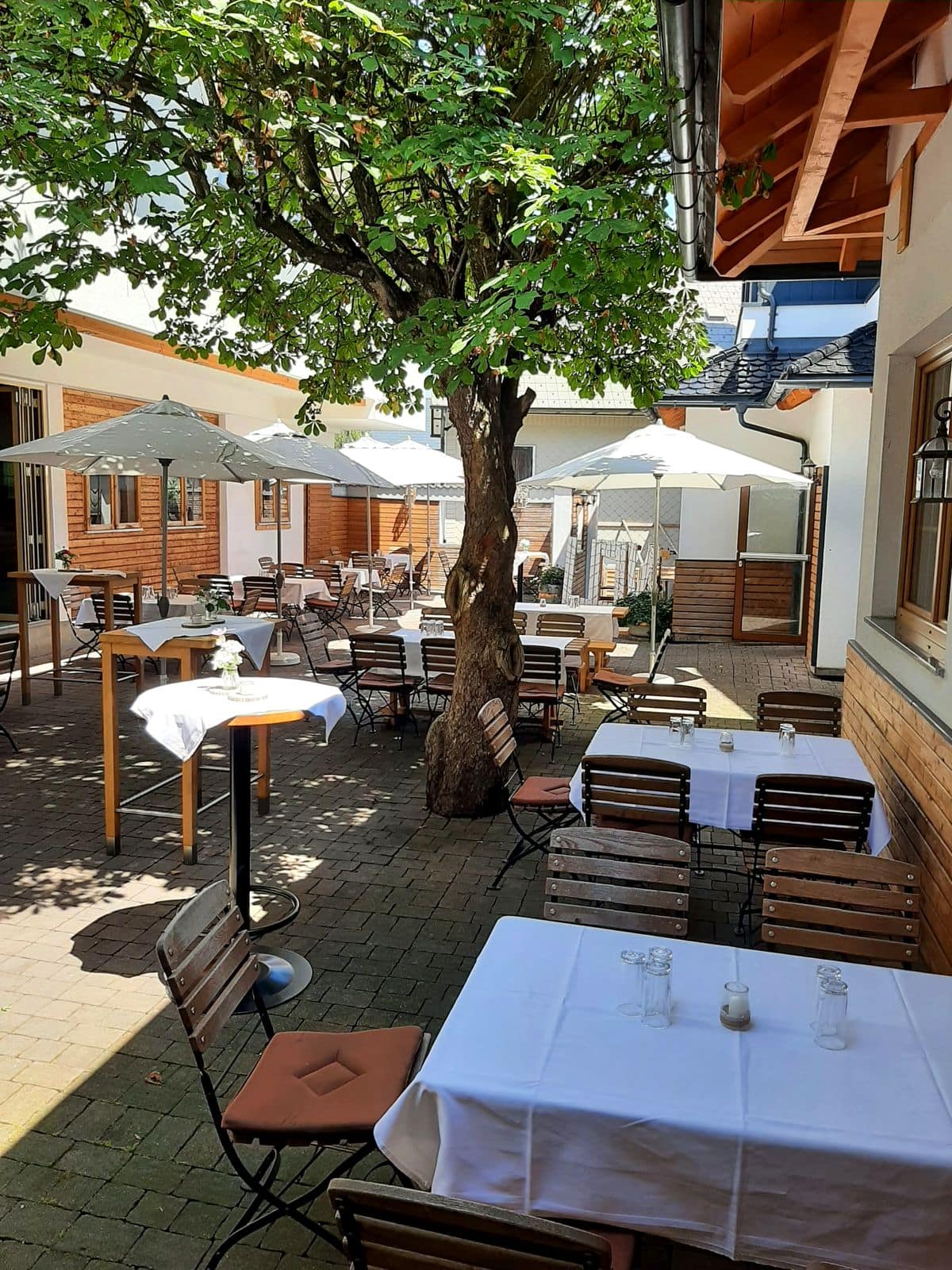Tische im schattigen Gastgarten